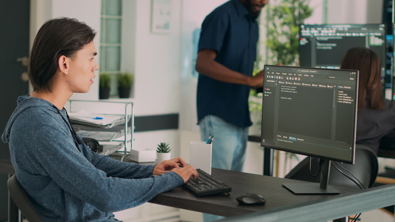 Asian programer developing database interface and writing server code