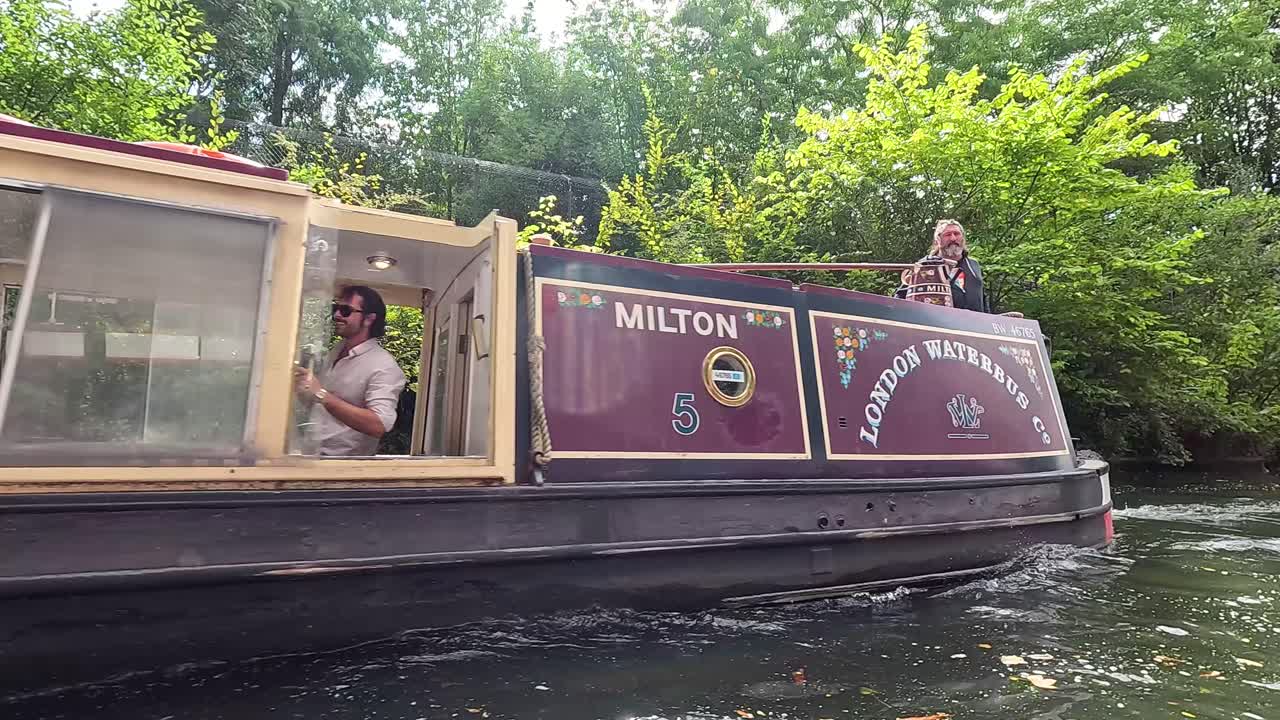 un barco estrecho que navega a través de la ciudad de camden