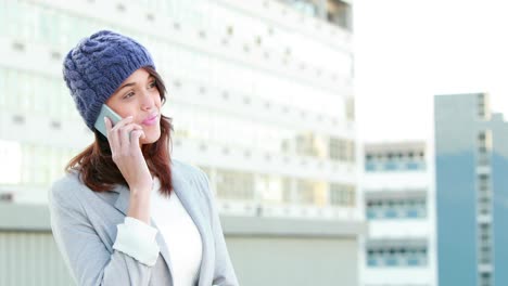 mujer sonriente en el teléfono con sombrero