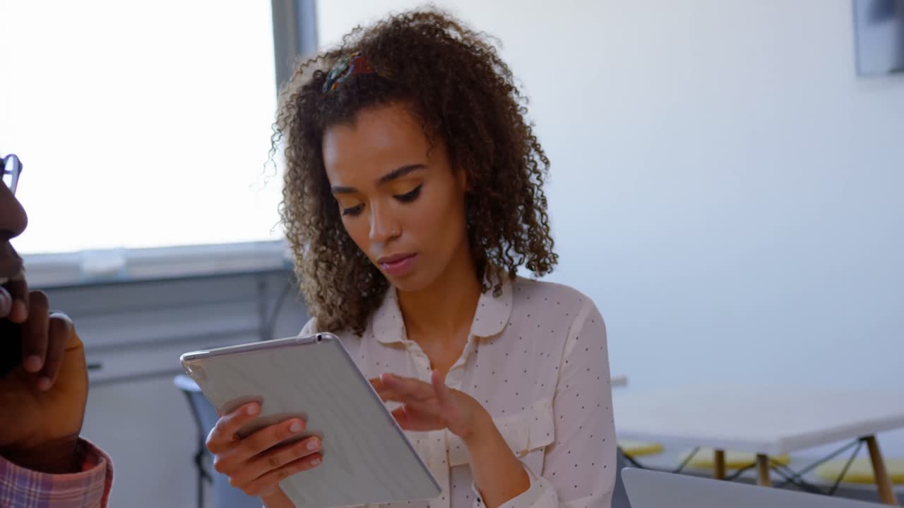 Beautiful mixed-race executive woman using digital tablet in modern office 4k