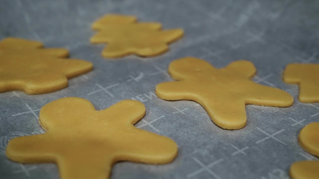 primer plano panorámico sobre la masa de galletas de azúcar en forma de vacaciones de navidad en una bandeja para hornear lista para entrar en el horno en una fría noche de invierno