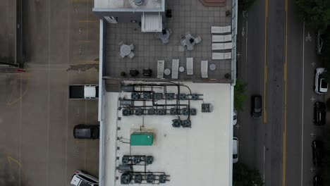 toma aerea sobre un edificio del que podemos ver su techo y una calle por donde circulan autos
