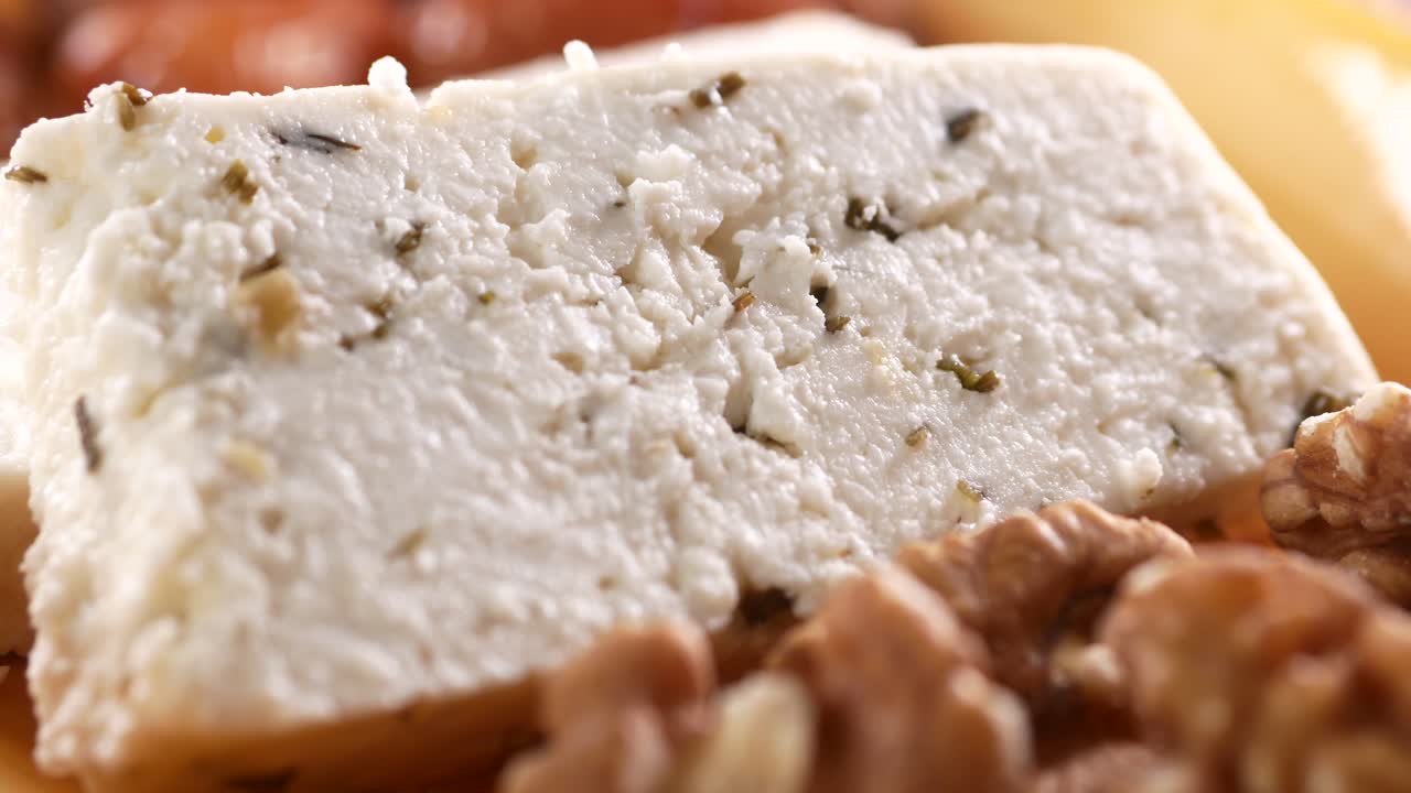 Close-up of Sliced White Cheese with Herbs and Walnuts