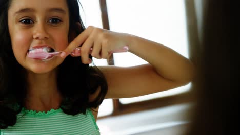 chica cepillándose los dientes en el baño