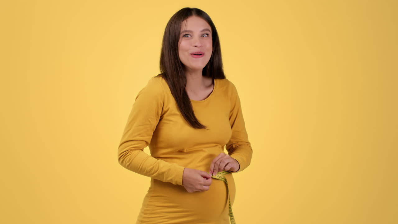 Happy Pregnant Woman Measuring Her Belly