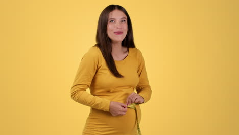 happy pregnant woman measuring her belly