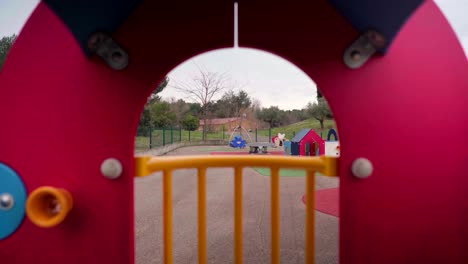 Leerer-Spielplatz-Während-Der-Sperrung-Der-Covid-19-coronavirus-pandemie,-Blick-Durch-Ein-Kubisches-Haus