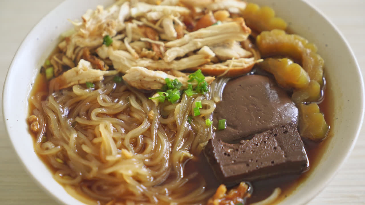 fideos de pollo guisados en tazón de sopa marrón - estilo de comida asiática