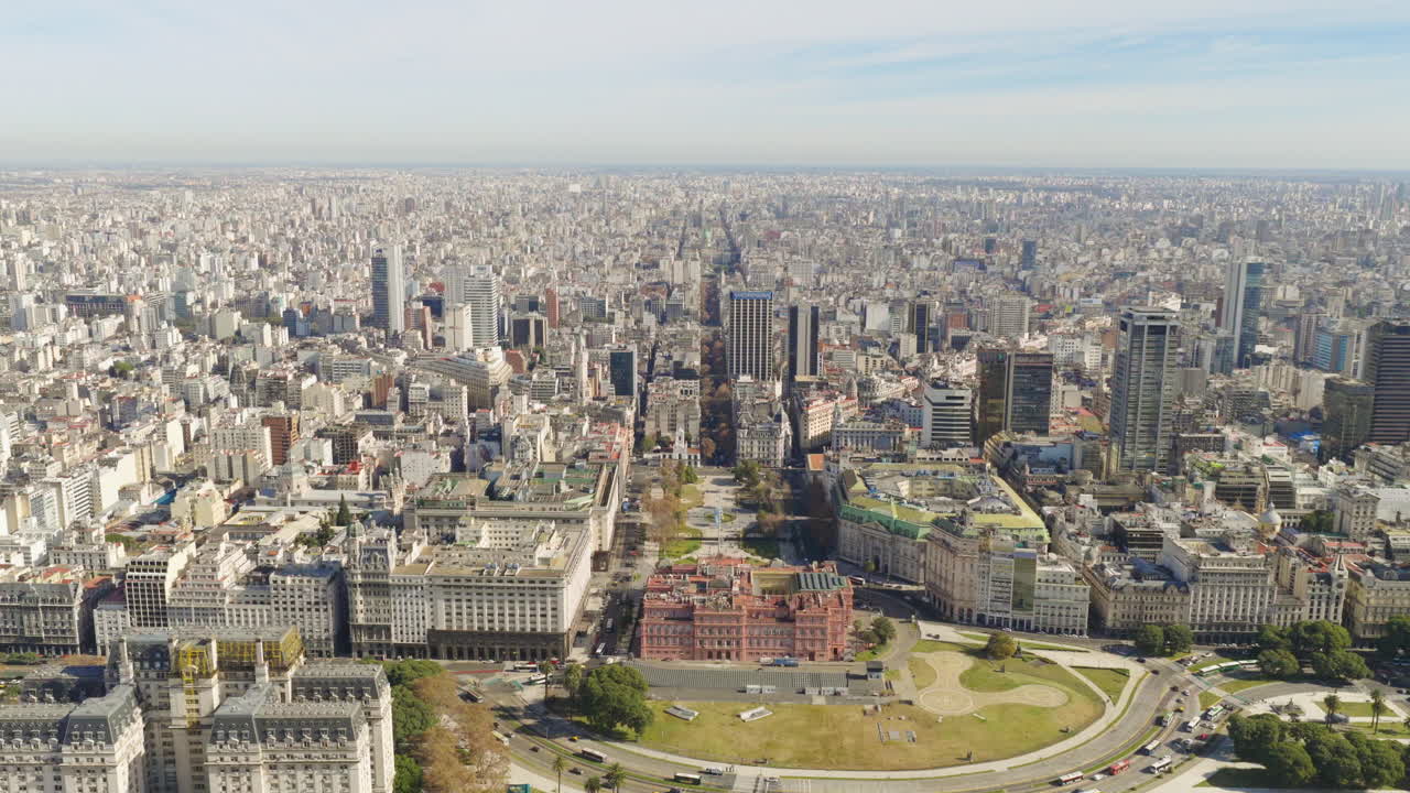Panoramic aerial movement over dense urban Casa Rosada cityscape with mix of modern and historical buildings, Buenos Aires, Argentina.