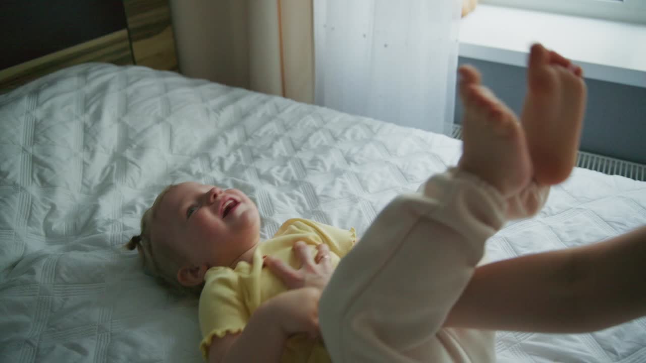 Bambino felice che ride giocando con la mamma sul letto