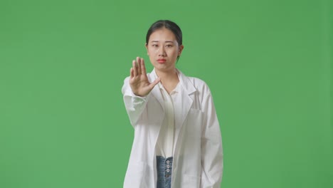 woman in lab coat gesturing stop