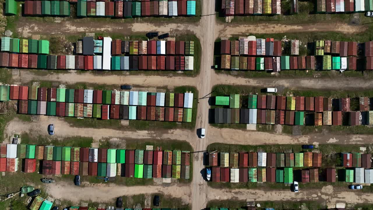 사람들이 다양한 종류의 사용된 자동차와 다른 재산을 보관하는 금속 차고의 배열의 공중 사진