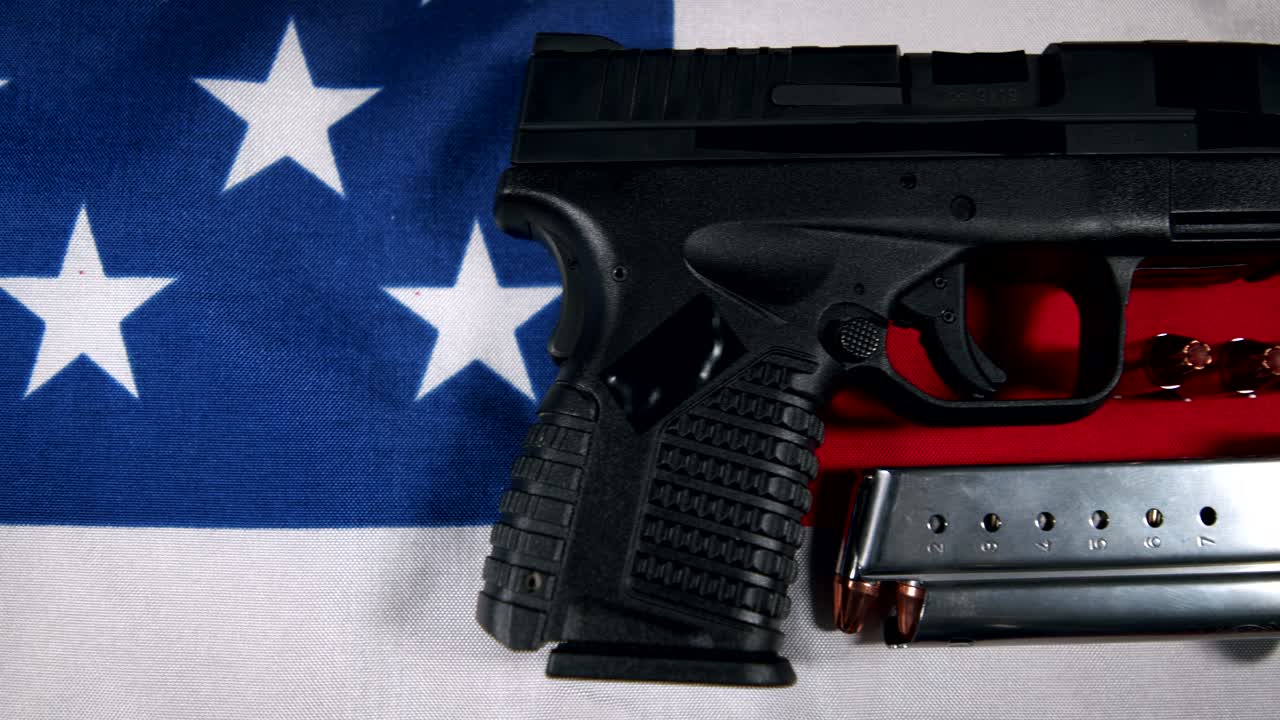 black Semi-Automatic 9mm Handgun on American flag with Loaded Magazine and Bullets, right hand side view, slow pan left to right, 4k