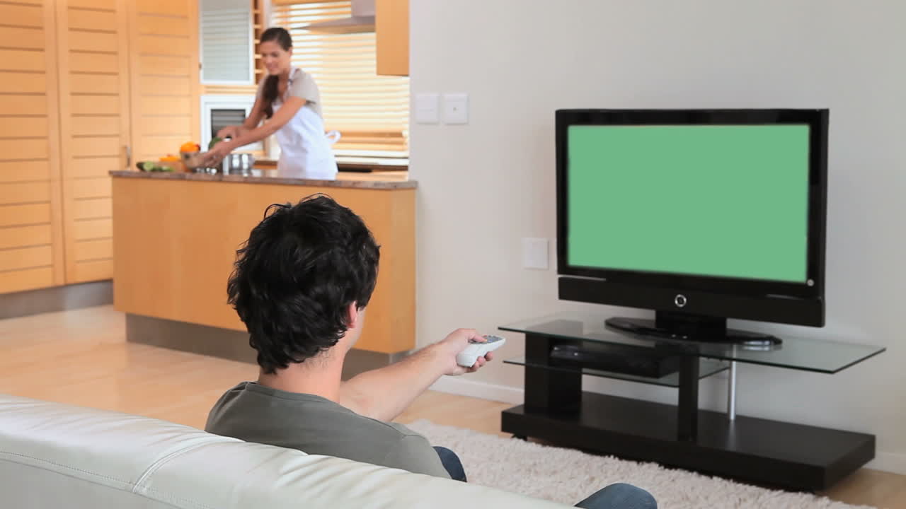 남자 는 텔레비전 에서 영화 를 보고 있다