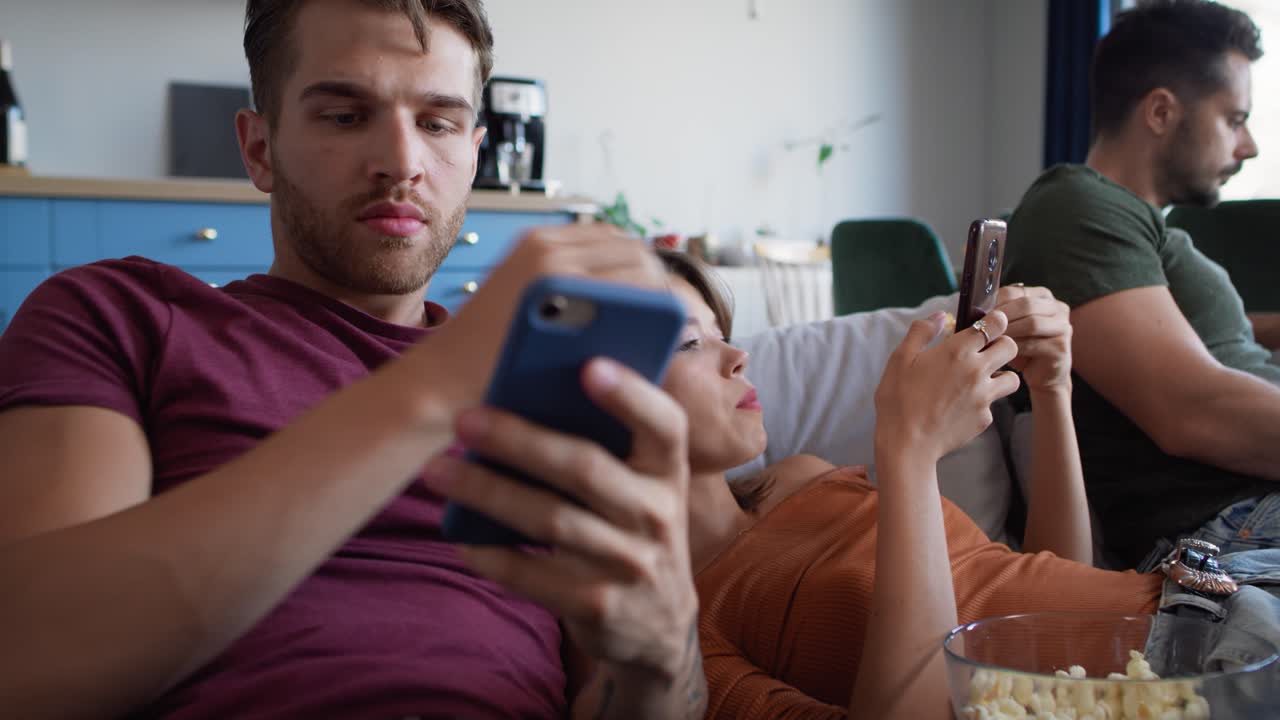 grupo de amigos usando teléfonos móviles en la fiesta en casa