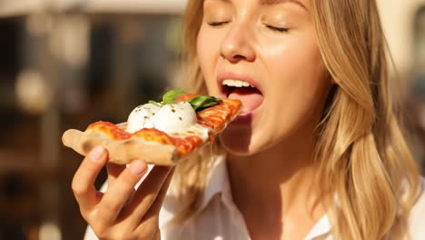 young woman enjoying a delicious slice of pizza