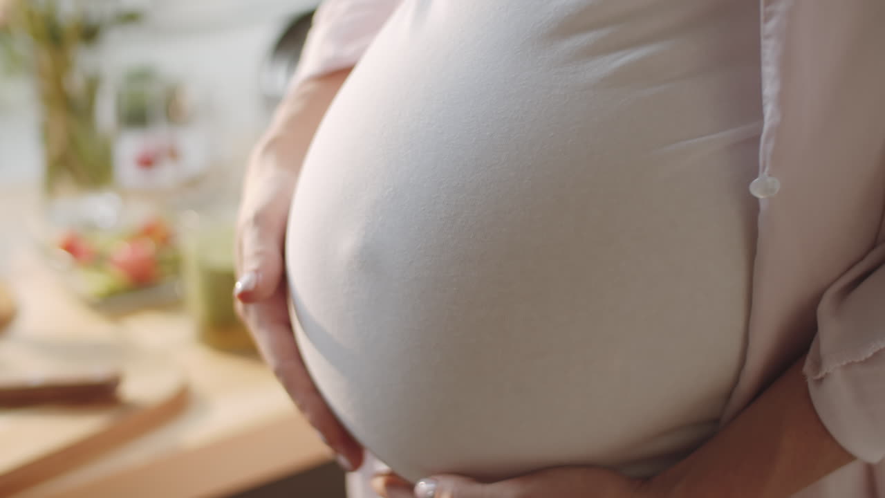 임신 한 여자 가 배 를 들고 있다