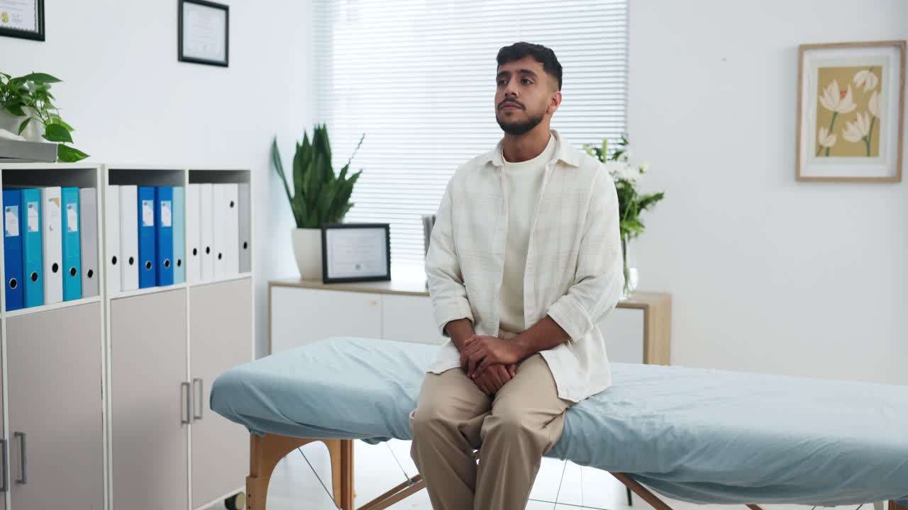 Young Man Patiently Waiting in a Doctor's Examination Room