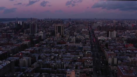 gorgeous aerial footage of the harlem neighborhood of new york city at sunset blue hour.  traffic headlights, george washington bridge in the distance.  in 4k.