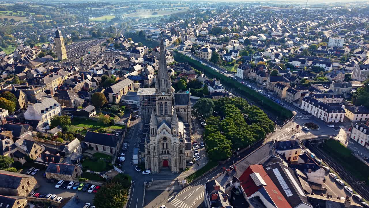 Iglesia de San Martín, mostrando la plaza del pueblo y el paisaje urbano de Vitré, Bretaña en Francia. Dron aéreo orbitando