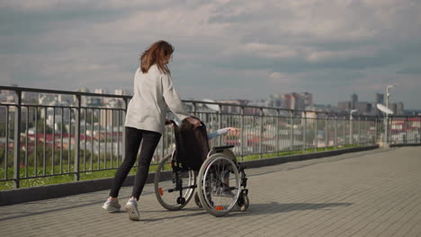 woman controls wheelchair with little girl spinning around