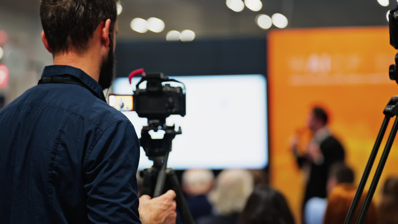 Man filming with a professional camera at a conference