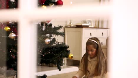 Niña-Abriendo-Regalos-Bajo-El-árbol-De-Navidad