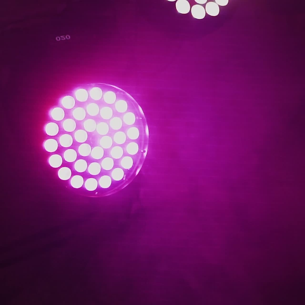 Equipamento de iluminação de palco. Holofotes girando e cintilando. Luminárias automatizadas suspensas no teto do salão e girando no interior escuro.