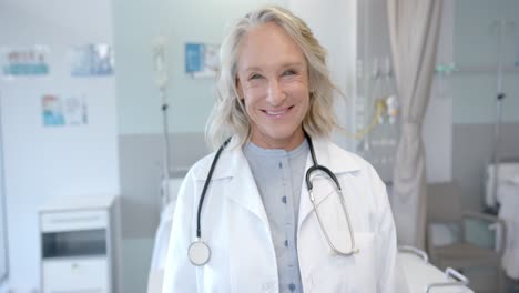 Portrait-of-happy-senior-caucasian-female-doctor-in-hospital-room,-slow-motion