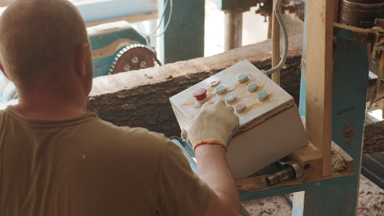Worker sets the program with the control panel on an automatic woodworking machine with a CNC