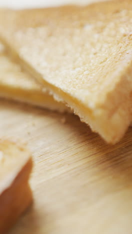 video de rebanadas de sándwiches de pan blanco con queso tostado en el fondo de la tabla de cortar de madera