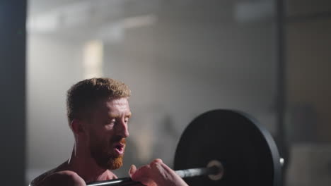 slow motion: fitness man bodybuilder training using barbell weightlifting exercise muscular sportsman power lifting heavy weight doing squats in gym practice enjoying healthy lifestyle