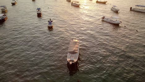 aerial - boats anchored at sunrise, coast of cancun, mexico, descending shot