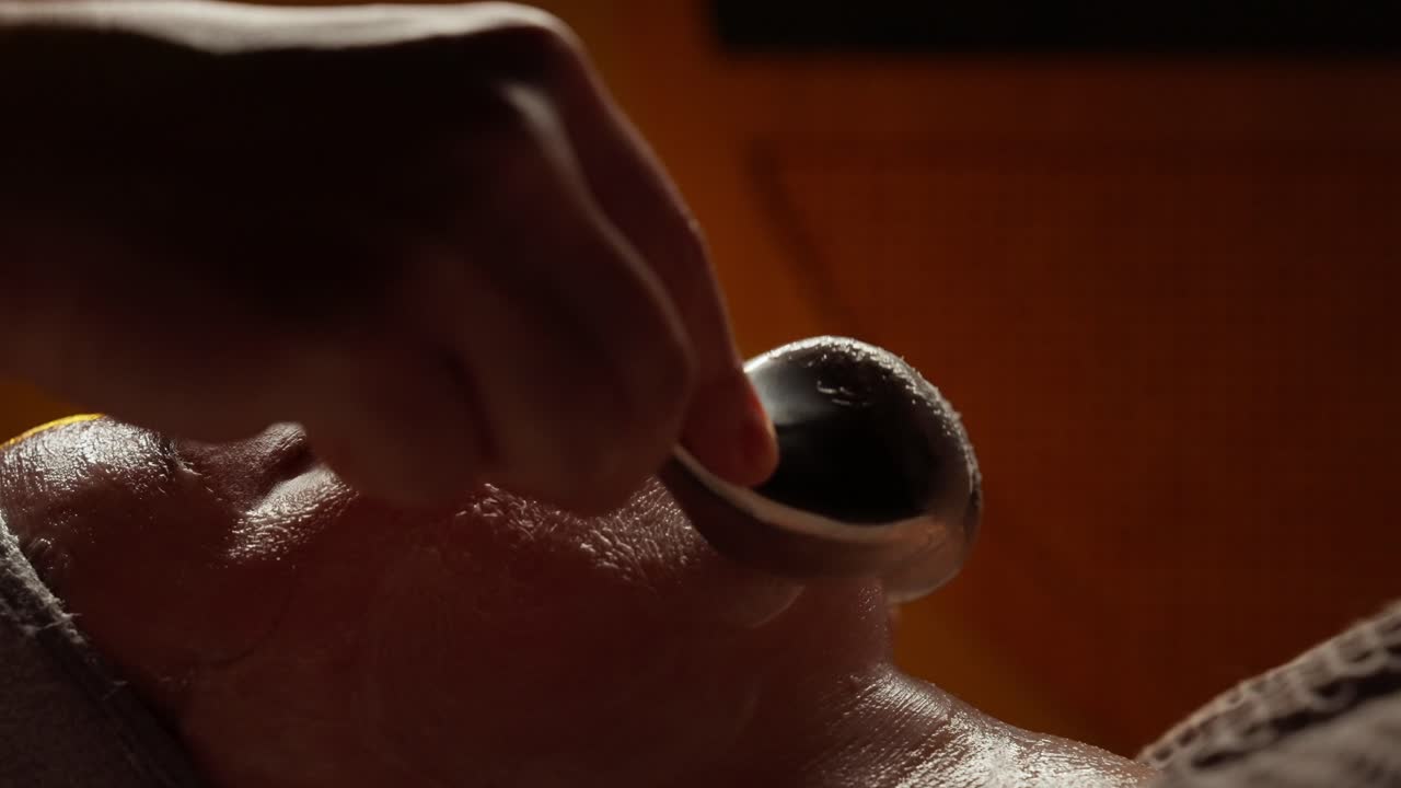 Primo piano di una donna che riceve un massaggio facciale con uno strumento di bellezza
