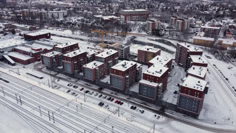 Modern-apartment-blocks-next-to-the-railroad-tracks-on-a-snowy-winter-day