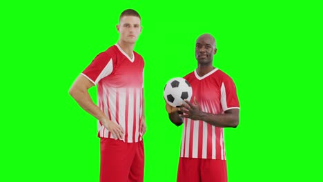 Video-of-two-diverse-male-soccer-players-with-ball-on-green-screen-background