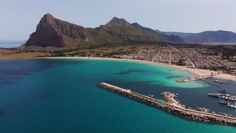 Backwards-Drone-Shot-Reveals-Breakwater-at-San-Vito-Lo-Capo-Beach-in-Trapani,-Sicily,-Italy