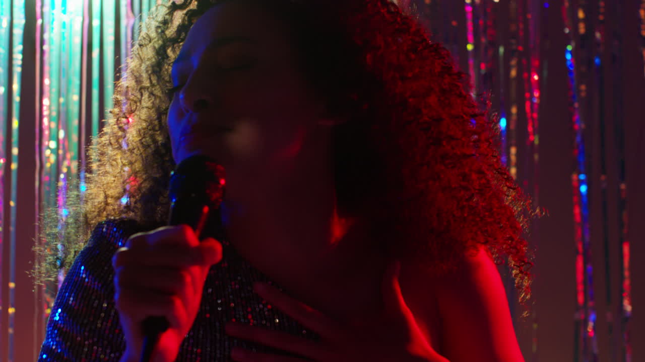 Young Woman With Microphone Singing At Karaoke Nightclub Bar Or Disco With Sparkling Lights In Background 2