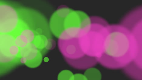círculos abstractos dinámicos círculos rosados y verdes borrosos en movimiento sobre fondo negro