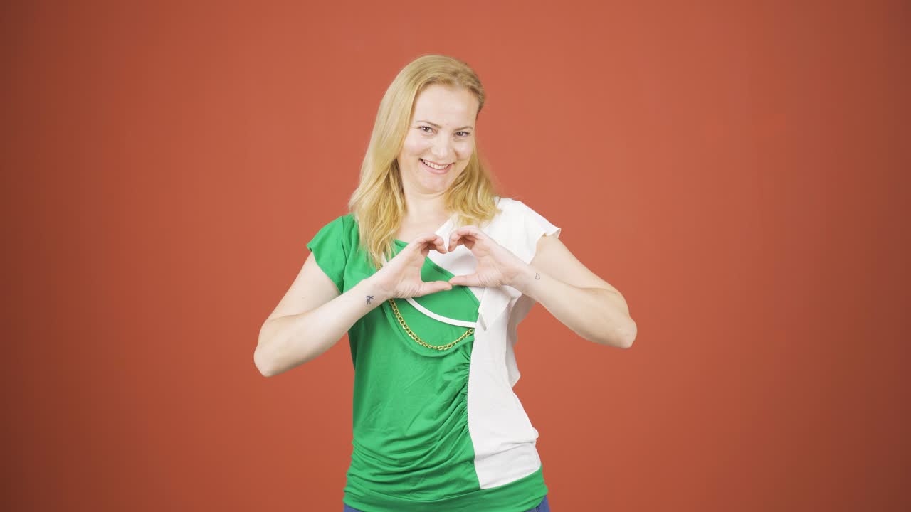 여성이 카메라에 심장 기호를 하고 있습니다.