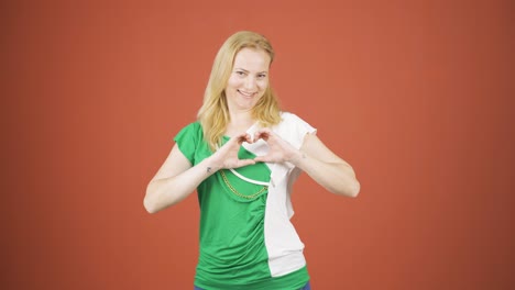 mujer haciendo una señal de corazón a la cámara.