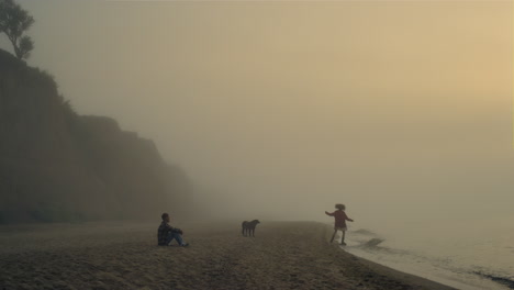 young couple spending leisure time on beach. girl and guy enjoying sunrise