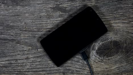 female hand plug cable into wireless charger and put phone on it