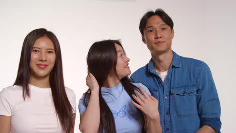 group of young friends in front of white studio background posing for photo booth style portraits