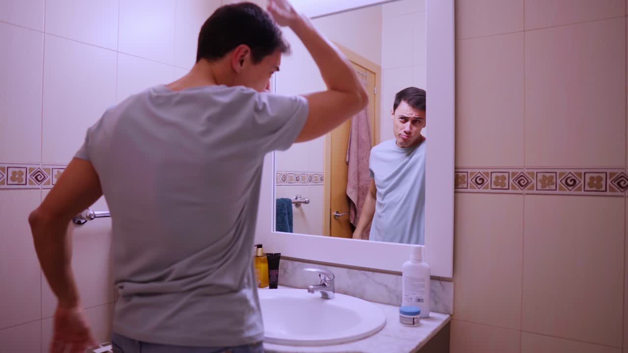 Narcissistic man admiring himself in bathroom mirror