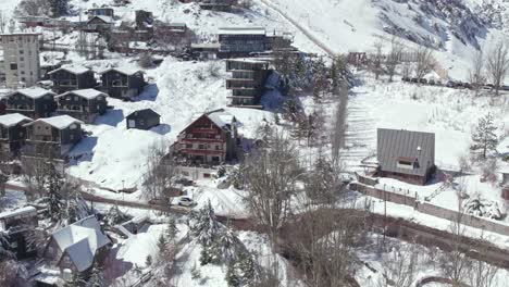 Drone-flying-towards-Modern-House-design-in-Farellones,-a-mountain-village-covered-in-Snow,-Chile