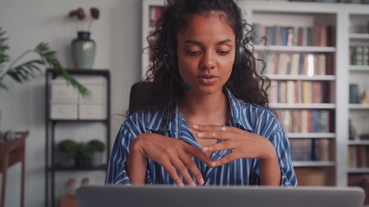 Young indian business woman wearing headset communicating by video call