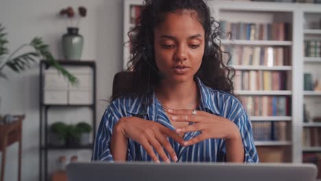 young indian business woman wearing headset communicating by video call