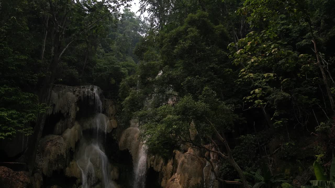 una impresionante cascada rodeada de exuberante vegetación y árboles, evocando un encanto de otro mundo