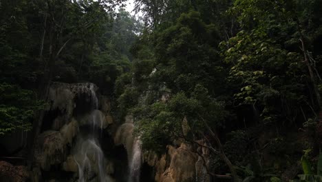 a stunning waterfall surrounded by lush greenery and trees, evoking an otherworldly charm